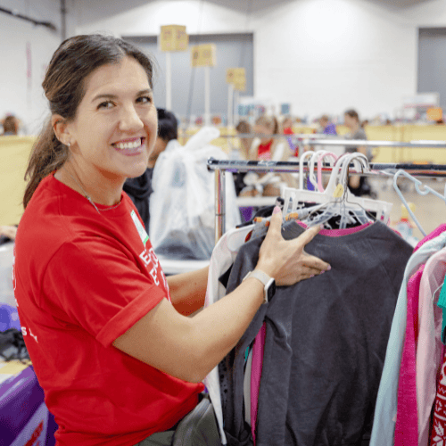 Mom holds daughter who is sleeping in her arms while she shops the local JBF sale.